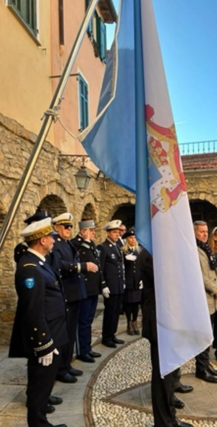 Levée des couleurs à Seborga : les membres de la Gendarmerie Abbatiale au garde-à-vous devant le drapeau du Sabourg