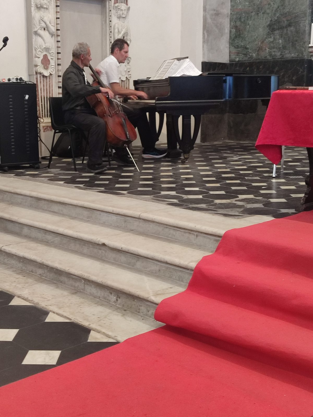 Violoncelliste et pianiste sur le chœur tapissé de rouge
